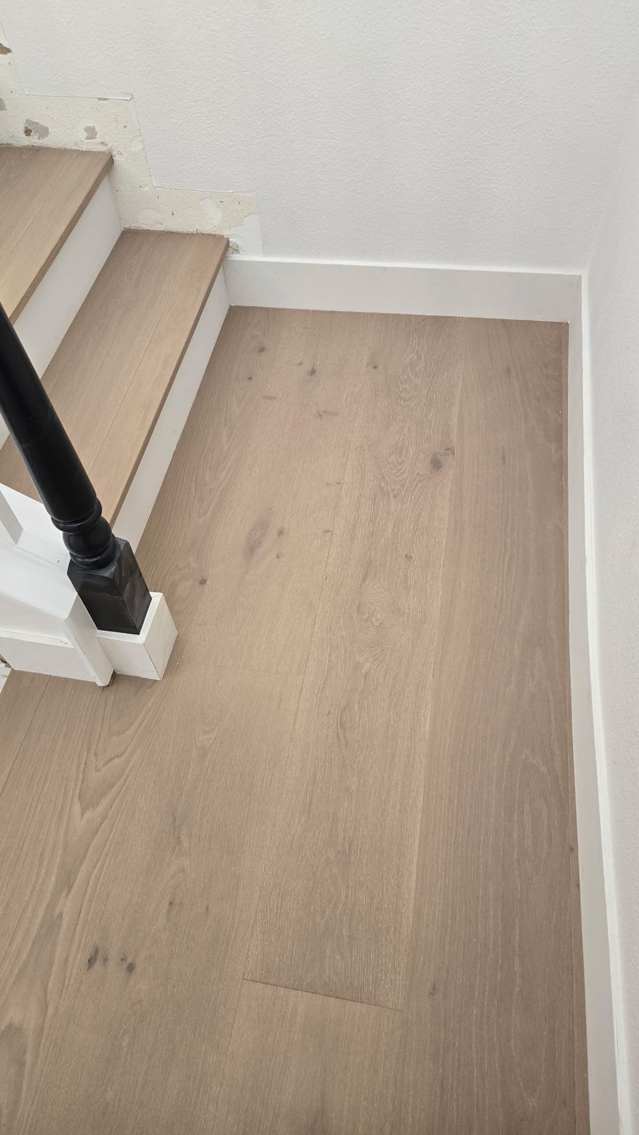 European oak hardwood landing at the base of stairs with white risers