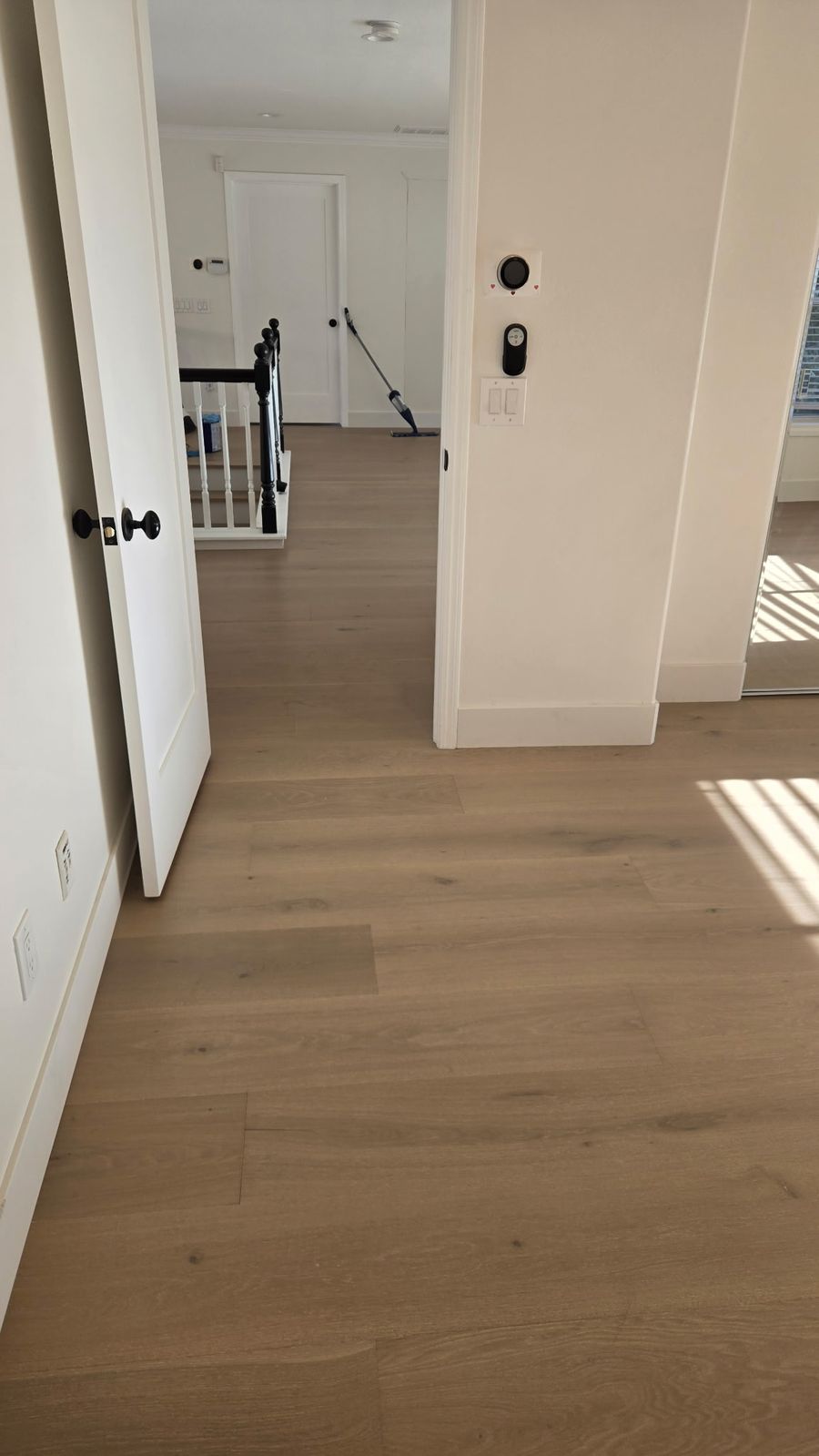 European oak hardwood flooring in an upstairs hallway leading to the stair railing