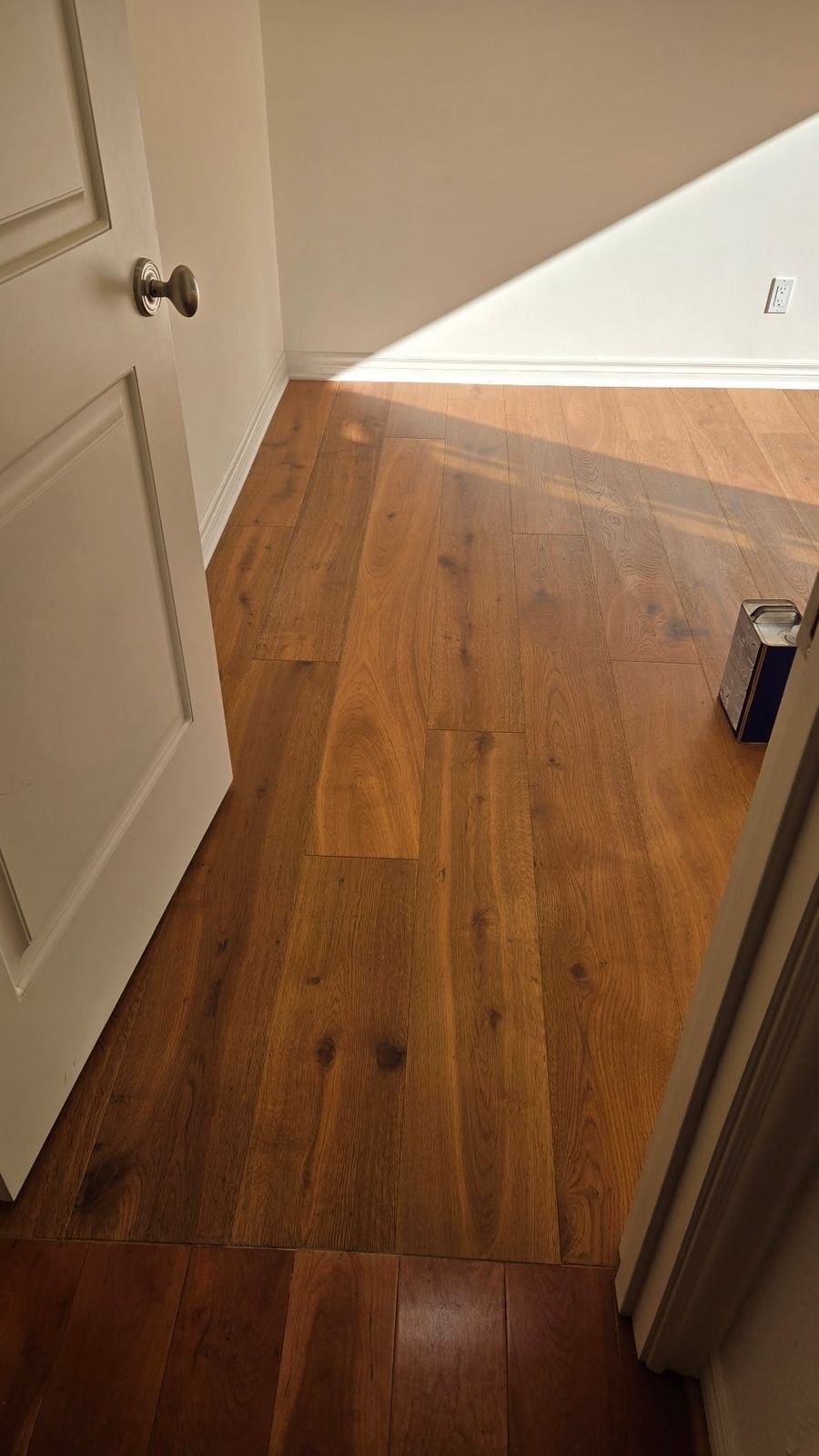 New French oak hardwood meeting the existing hallway floor at a doorway