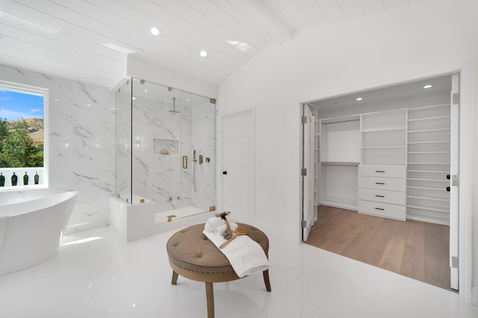 Master bathroom remodel with glass walk-in shower, shower bench and freestanding tub