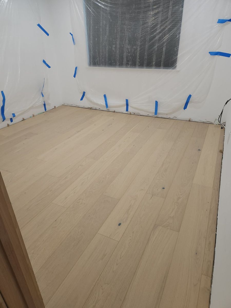 Oak hardwood flooring in a Calabasas bedroom with expansion spacers along the walls