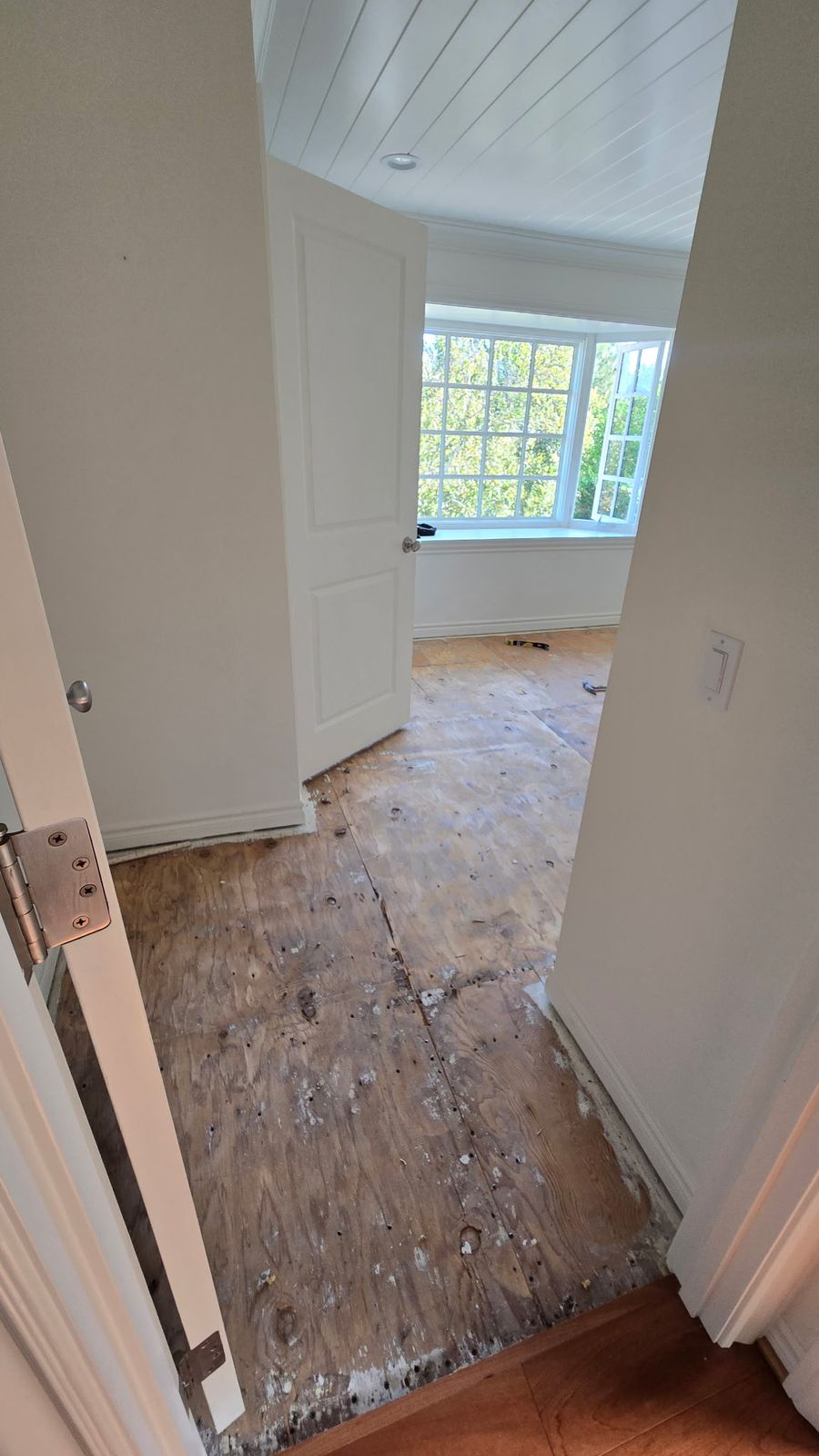 Exposed plywood subfloor with fastener holes before hardwood installation in Woodland Hills
