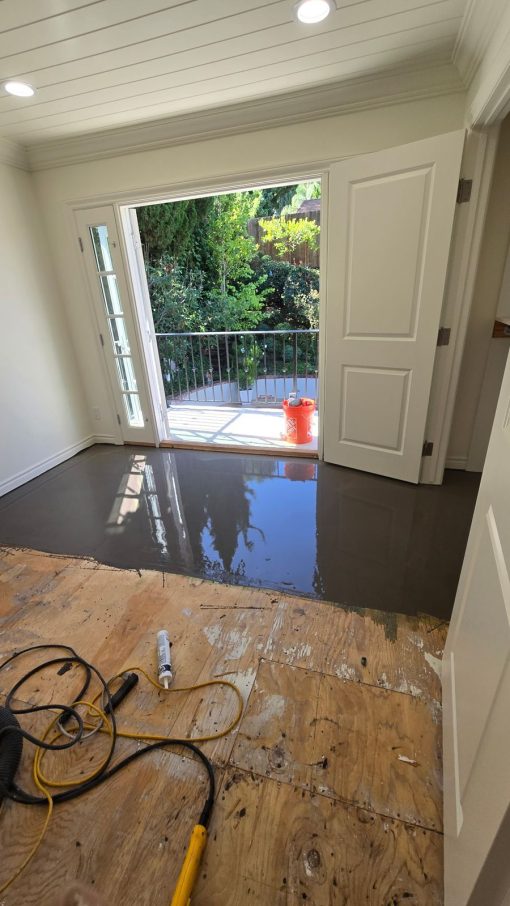 Self-leveling material poured over the plywood subfloor before hardwood installation in Woodland Hills