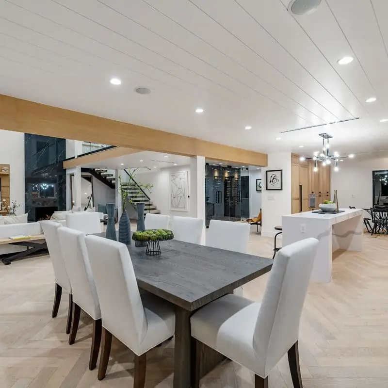 Light white oak herringbone flooring in an open kitchen and dining area