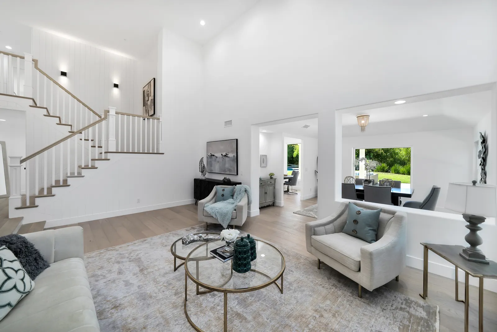 Two-story entry and living room with a staircase over light hardwood, Granada Hills, Glamour Flooring project