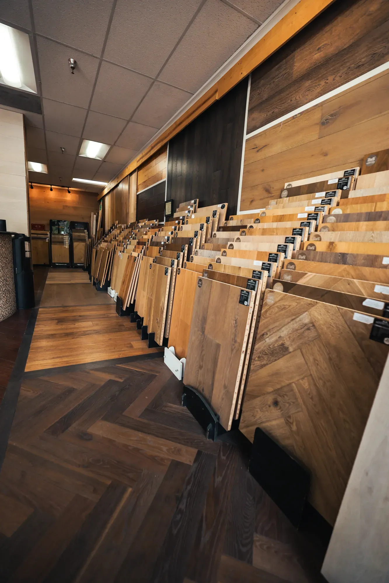 Hardwood sample racks over a herringbone floor in the Glamour Flooring showroom
