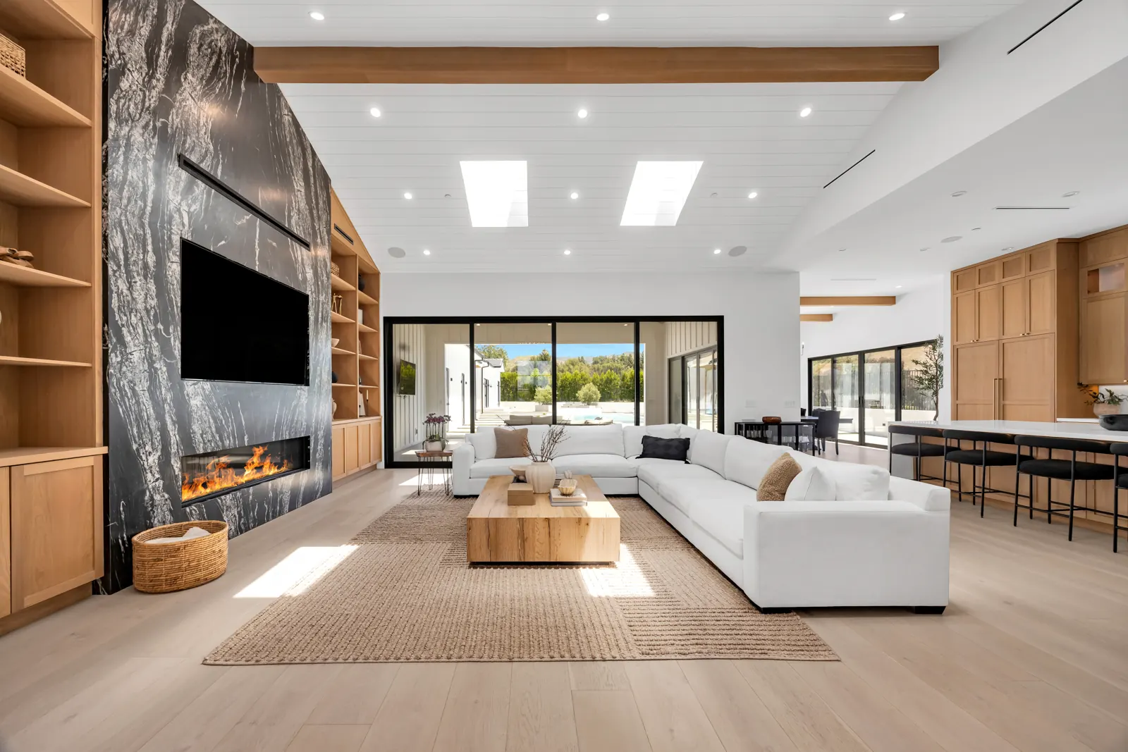 Great room with light wide-plank hardwood, oak built-ins and stone fireplace wall, Porter Ranch, Glamour Flooring project