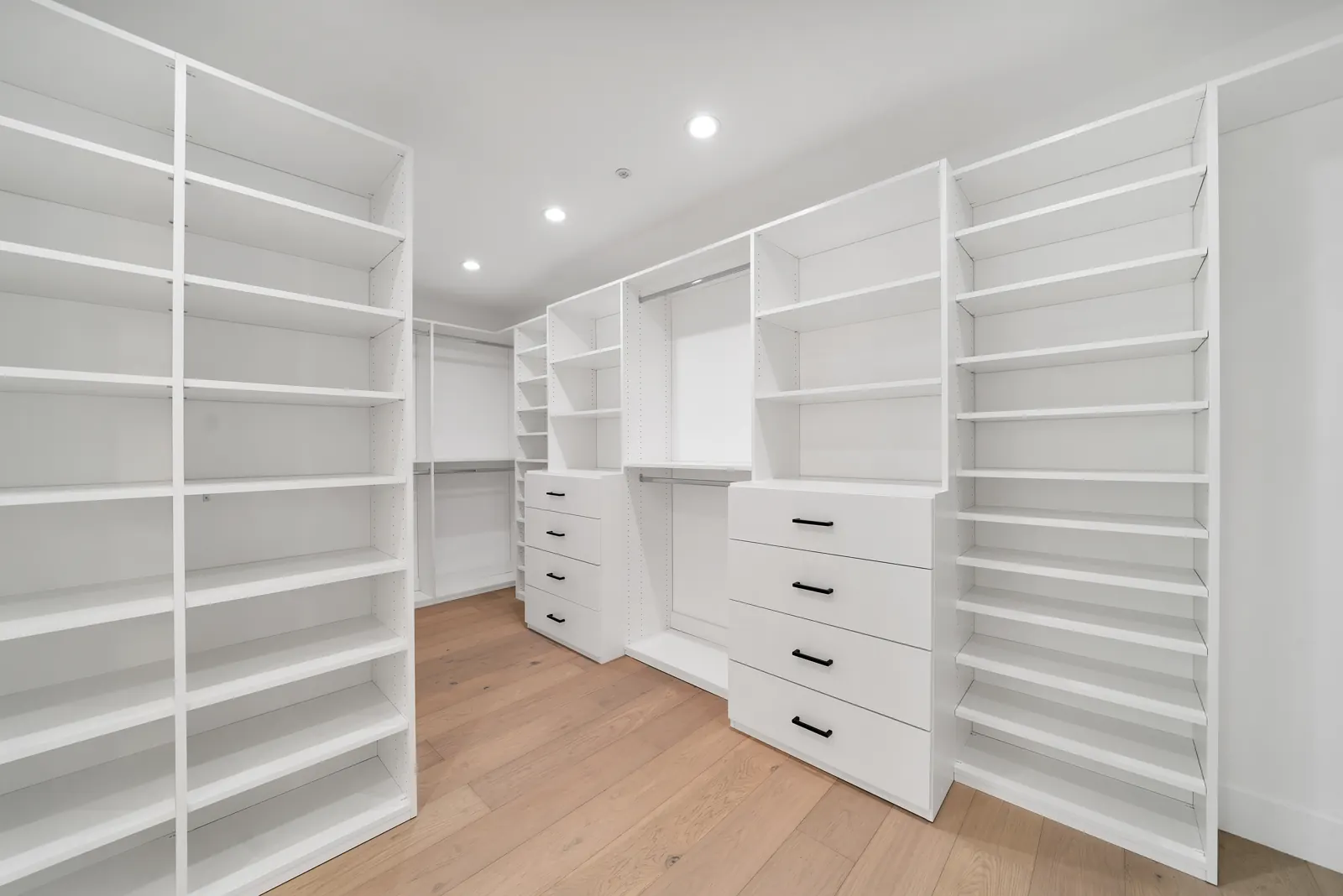 Walk-in closet with white built-ins and light hardwood, Granada Hills, Glamour Flooring project